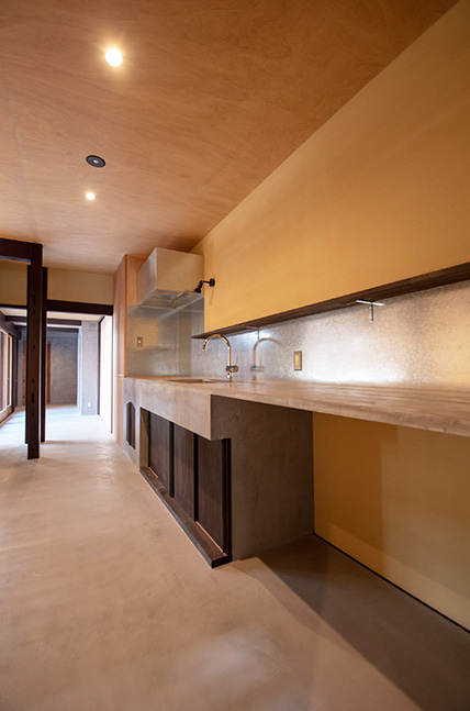 モルタルの床など、シンプルな素材遣いの1階のキッチン。十分な広さがあり、ケータリングなどにも対応可。